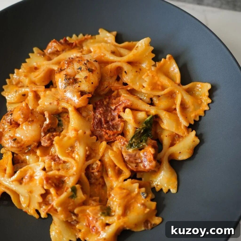 Creamy sun dried tomato pasta in a black bowl.